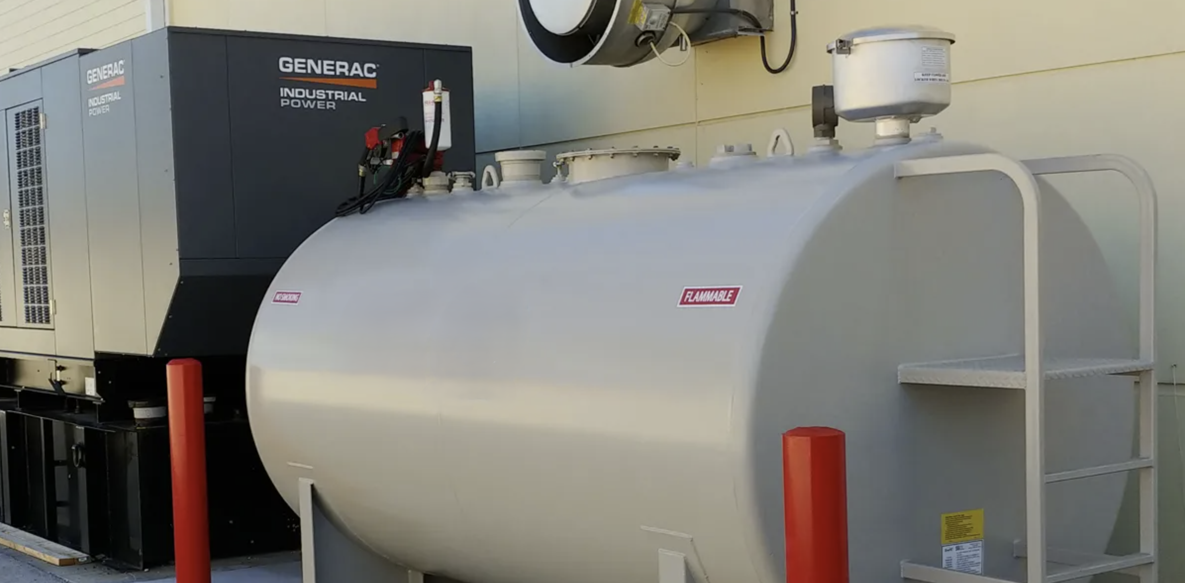 Photo of an above ground diesel fuel tank in the foreground with a Generac commercial generator in the background. The tank is gray and the generator is black